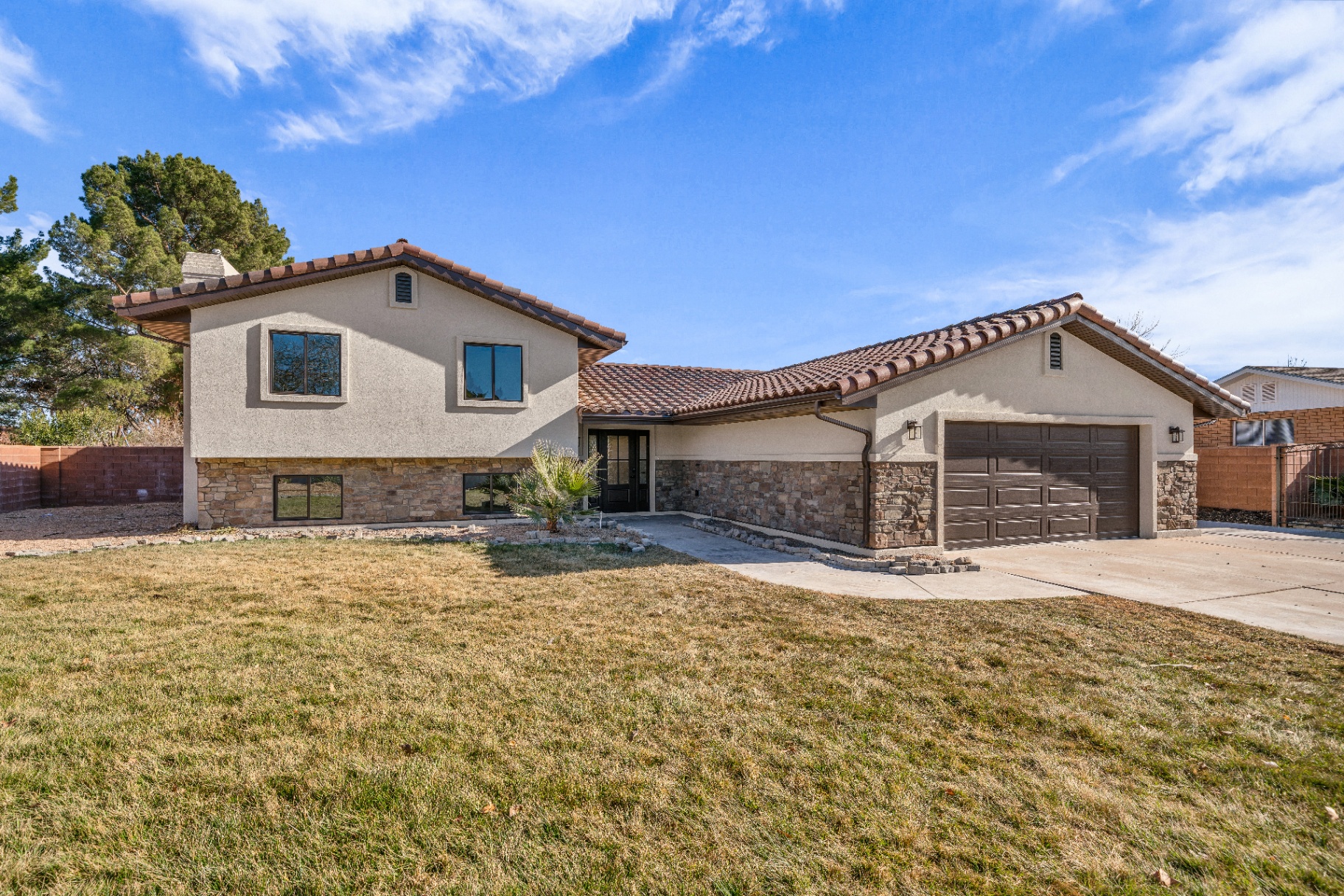 Home exterior with tile roof and attached garage from a Prestigious Home Builders remodel