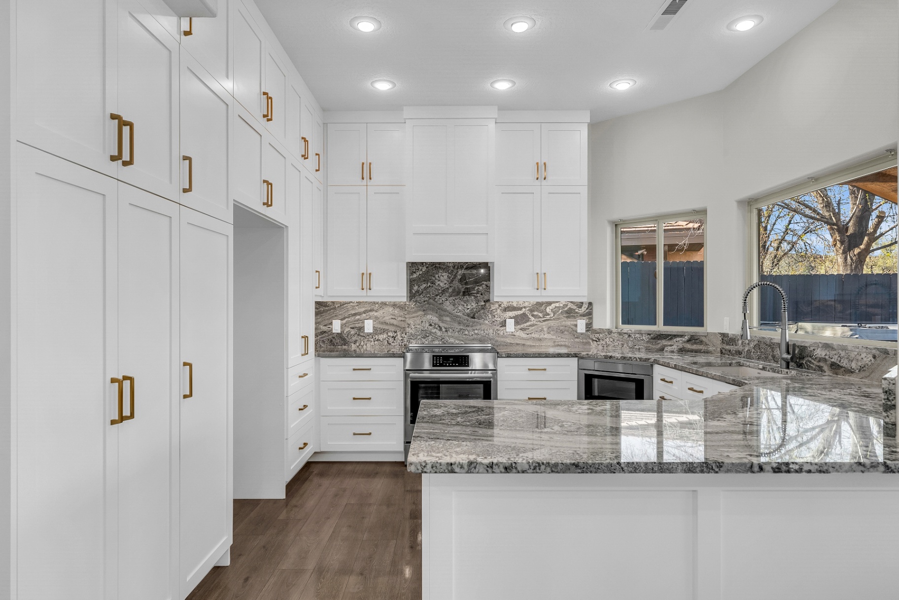 Remodeled white and gold kitchen by Prestigious Home Builders